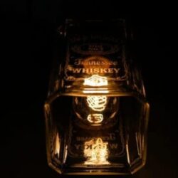 Handcrafted personalized glass bottle lamp illuminating a cozy space