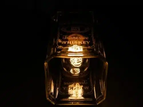 Handcrafted personalized glass bottle lamp illuminating a cozy space