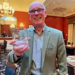 Colin Scott holding his personalized Green Glass Ultis whisky glass engraved with his name