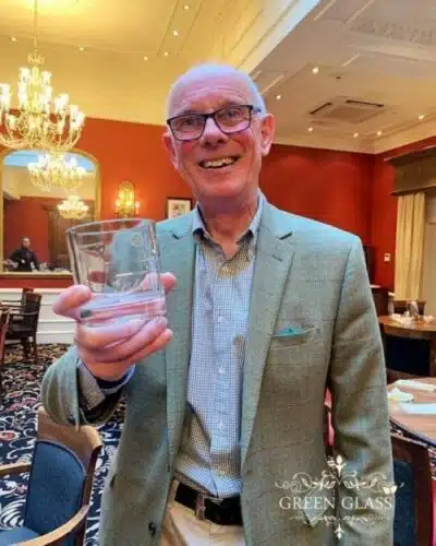 Colin Scott holding his personalized Green Glass Ultis whisky glass engraved with his name